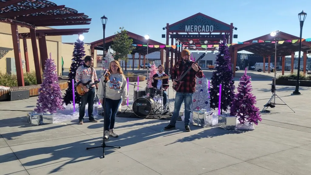 The four of us playing among purple and white Christmas trees at the STCU video shoot