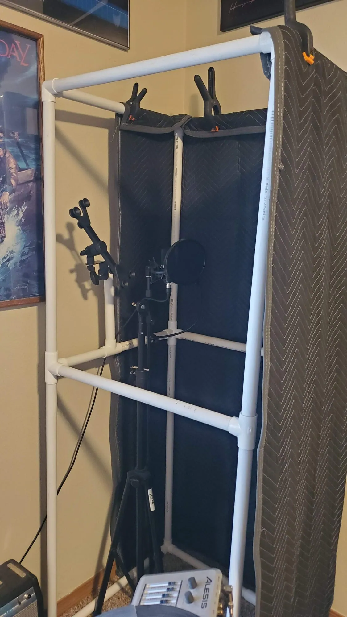 Our new recording booth open at the front: a white PVC pipe frame with moving blankets around a mic and pop filter.