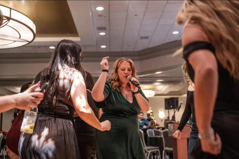 Our singer, microphone in hand, dancing with guests on the dance floor